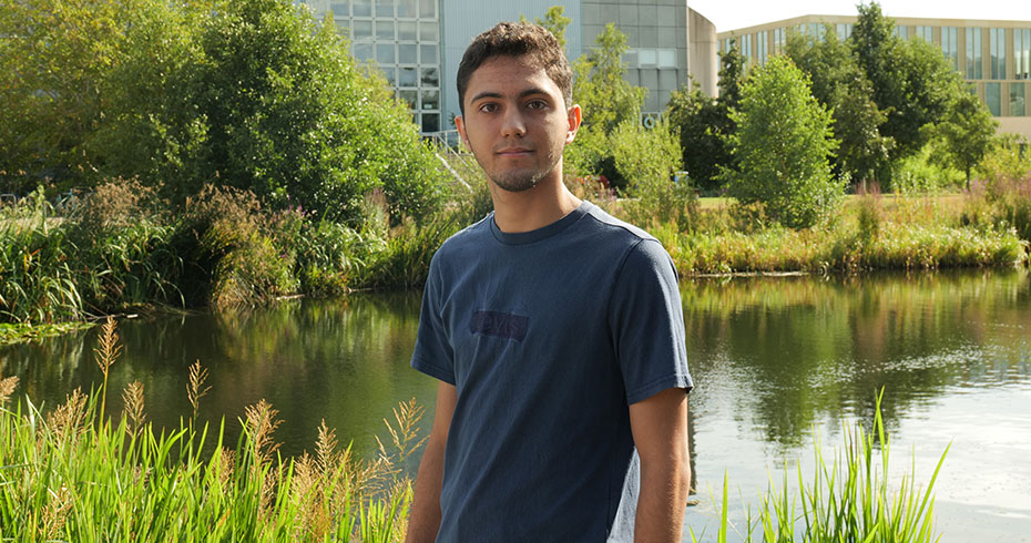 An image of a UCD Global Guide standing in front of the upper lake on a sunny day.